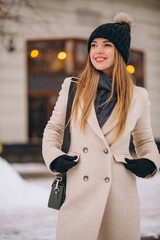 Woman in coat standing outside the cafe in a winter street