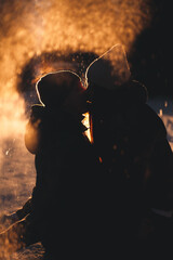 Silhouette of a guy and a girl kissing on a winter road. Atmospheric photo for Valentine's Day