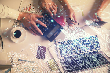 Double exposure of man and woman working together and the buildings hologram drawing. Computer background. Top View. Smart city concept.