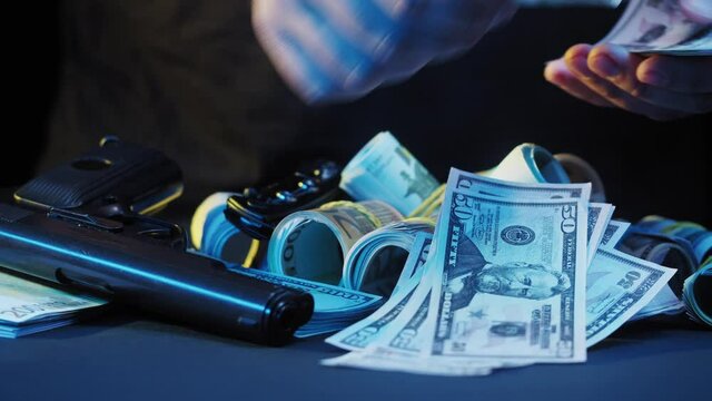 Counting money cash close-up. Euro and dollar banknotes with gun on black background. Crime and theft concept.