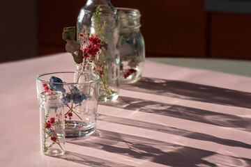 a glass bottle with flowers in it. Beautiful shadows