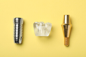 Parts of dental implant on yellow background, flat lay - obrazy, fototapety, plakaty