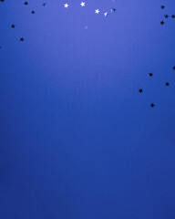 Dark blue stars shapes at the top on blue background. Christmas winter holiday concept flat lay top view with copy space