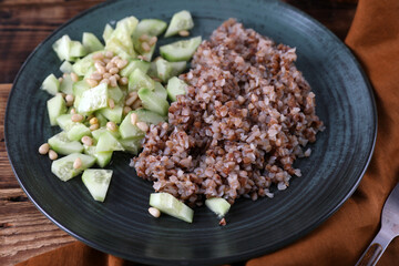Boiled buckwheat and cucumbers with olive oil and pine nuts
