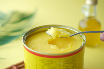 ghee in container on yellow background 