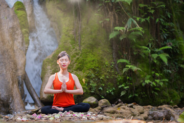 asian woman playing yoga in waterfall outdoor nature background.