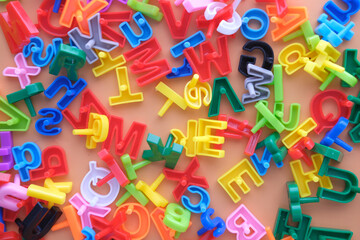 colorful plastic letters on orange background, Top view 