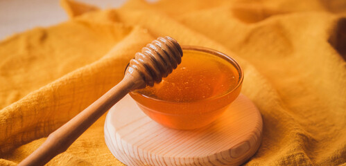 Thick sweet tasty honey in a bowl. Wooden spoon for honey. Sugar substitute. Natural sweetness.