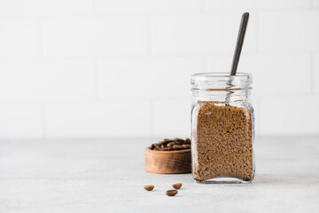 A glass jar with instant coffee and a teaspoon. Copy space.