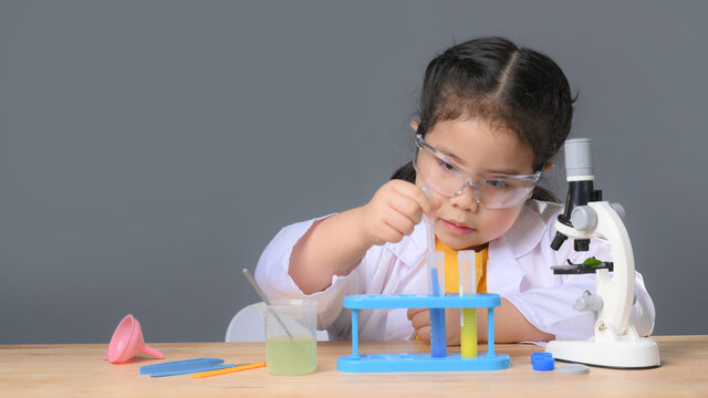 Asian child girl learning science chemistry with test tube making experiment at school laboratory. education, science, chemistry and children concept . Early development of children.