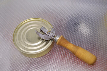a can opener next to a tin can in the fridge