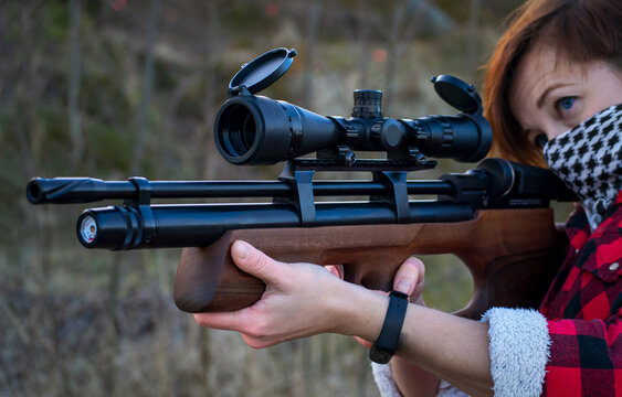 person aiming a pcp gun. Armed woman. Outdoor sport shooting