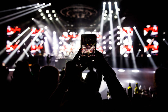 Making video recordings and pics on a smartphone at the concert or light show for publishing on social media.