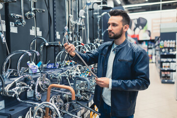 a customer in a hardware store in the plumbing department chooses a faucet for the kitchen