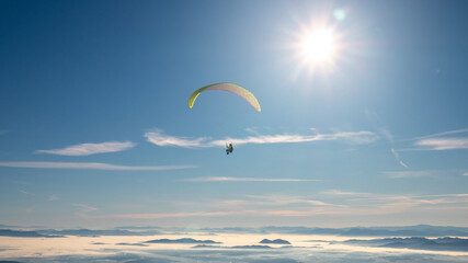 Paragliding with parachute at clear sunny sky in winter.