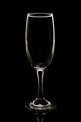 Isolated and illuminated empty champagne glass against black background