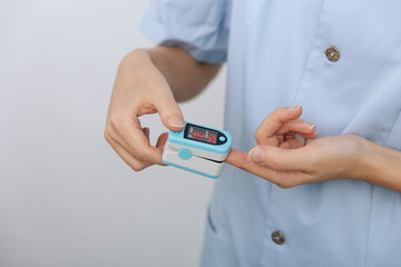 Pulse oximeter with hand of doctor isolated on white. The concept of portable digital device to measure person's oxygen saturation. Measuring oxygen saturation, pulse rate and oxygen levels.