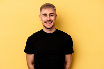 Young caucasian man isolated on yellow background happy, smiling and cheerful.