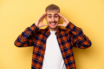 Young caucasian man isolated on yellow background receiving a pleasant surprise, excited and raising hands.