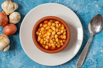 Hot turkish bean stew on blue background. Ispir beans cooked in a casserole - Kuru Fasulye