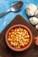 Hot turkish bean stew on blue background. Ispir beans cooked in a casserole - Kuru Fasulye