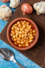 Hot turkish bean stew on blue background. Ispir beans cooked in a casserole - Kuru Fasulye