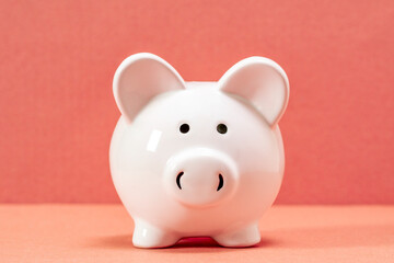 Close-up of white piggy bank on pink background