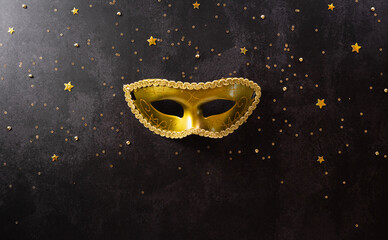Happy Purim carnival decoration concept made from golden mask and sparkle star on dark background. (Happy Purim in Hebrew, jewish holiday celebrate) - obrazy, fototapety, plakaty