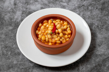 Hot turkish bean stew on dark background. Ispir beans cooked in a casserole - Kuru Fasulye