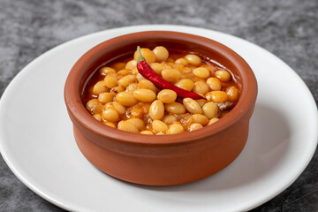 Hot turkish bean stew on dark background. Ispir beans cooked in a casserole - Kuru Fasulye