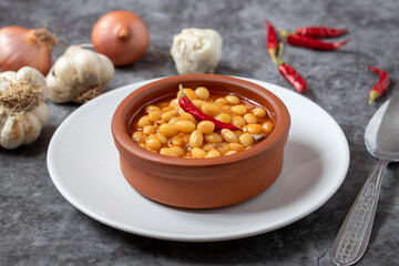Hot turkish bean stew on dark background. Ispir beans cooked in a casserole - Kuru Fasulye