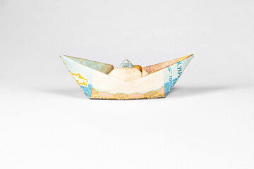Fototapeta premium boat made from a paper bill of the Ukrainian hryvnia