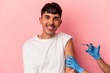 Young mixed race man getting the vaccine isolated on pink background