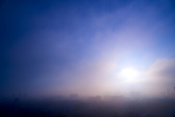 Obraz na płótnie Canvas Foggy cityscape at sunset time.