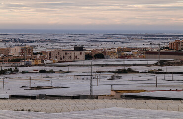 Fototapeta na wymiar Landscape of plastic greenhouses against cloudy sky in Almeria, Spain