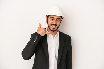 Young architect man wearing a construction helmet isolated on white background showing a mobile phone call gesture with fingers.