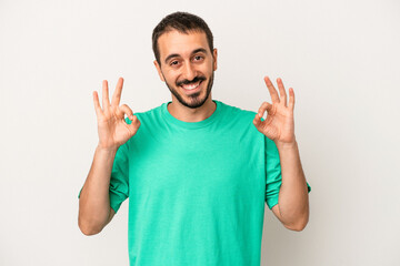 Young caucasian man isolated on white background cheerful and confident showing ok gesture.