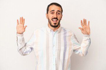Young caucasian man isolated on white background being shocked due to an imminent danger