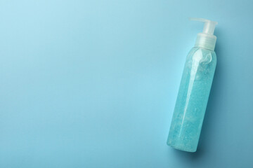 Bottle of cosmetic gel on light blue background, top view. Space for text