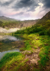 Beautiful footpath by a mountain lake
in dramatic light with dark clouds 
