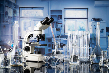 Laboratory investigations concerning test and medicine against covid. Microscope, glass tubes and beakers in the laboratory.
