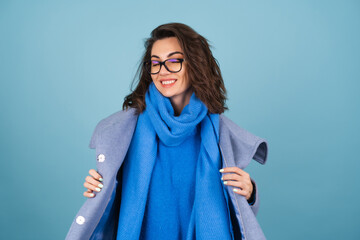 Spring autumn portrait of a woman in a blue knitted sweater, scarf and gray coat, posing...