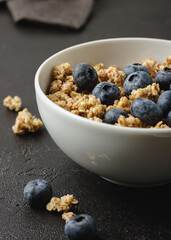 Granola with berries in white bowl.