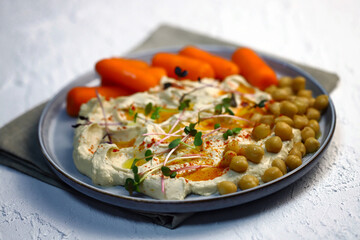 Hummus with carrots on a plate.