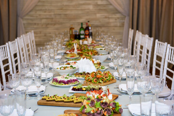 Snacks and dishes on the festive table. Reception of a large number of people in the restaurant.