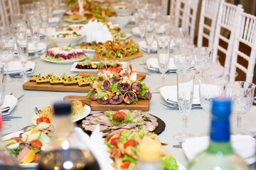 Snacks and dishes on the festive table. Reception of a large number of people in the restaurant.