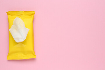 Wet wipes flow pack on pink background, top view. Space for text