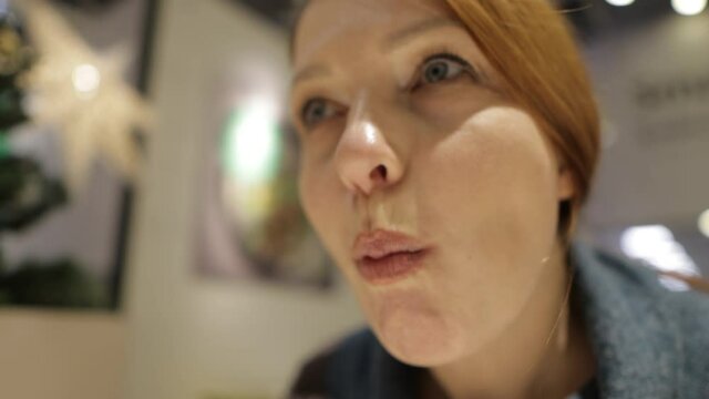 a woman eats fried pork knuckle with broccoli in a restaurant