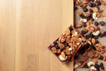 Naklejka na ściany i meble Mix of nuts and raisins on a wooden table.
