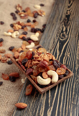 Mix of nuts and raisins on a wooden table.